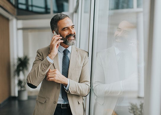 Man on the phone with someone, smiling.