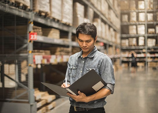 Business owner taking inventory in a warehouse.