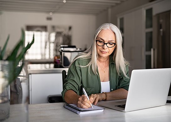 Woman working with notebook and laptop.