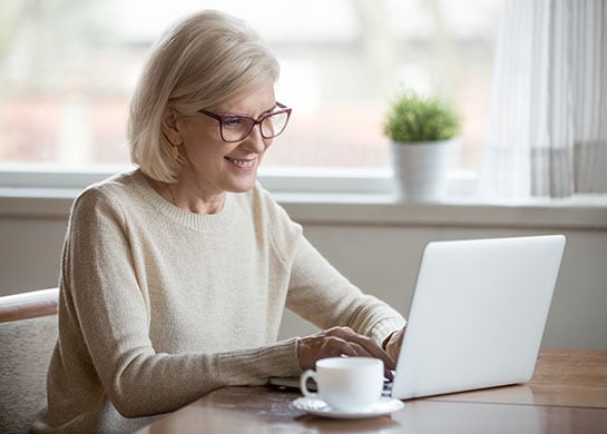 Woman on her laptop, smiling.