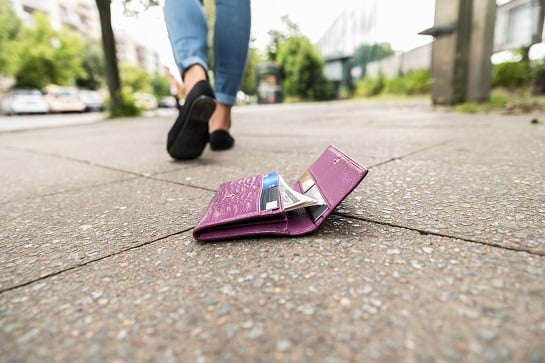 Lady walking away from her wallet on the ground 