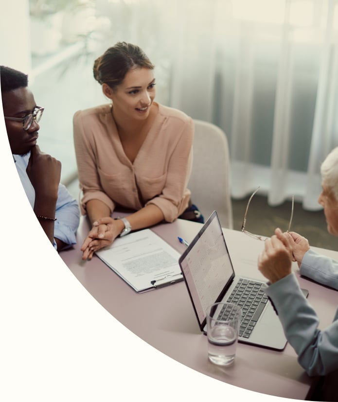 Young woman and her African American couple talking to their financial institution's branch advisor during a meeting in the office.