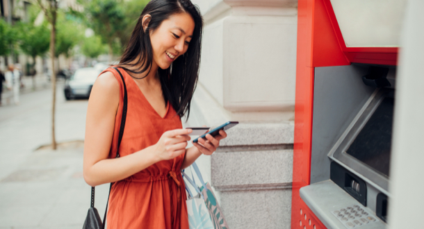 Asian girl taking money from an ATM machine