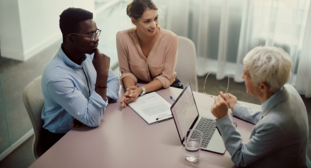 Young woman and couple sitting at table talking about branch operations during a meeting in an office