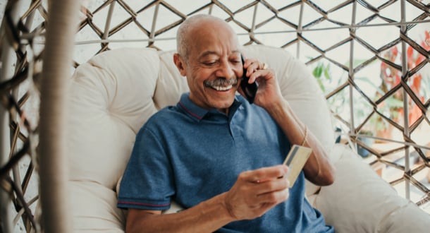 Senior man on the telephone holding credit card 