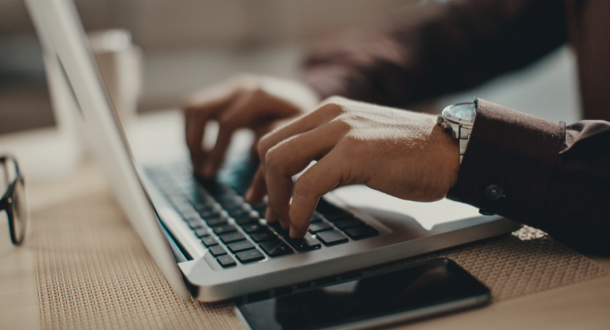 Closeup of man typing on laptop