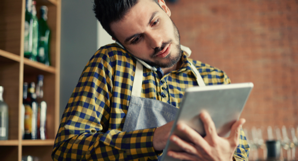 Waiter using smart phone and digital tablet