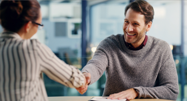 two business colleagues sitting in the office together and shaking hands