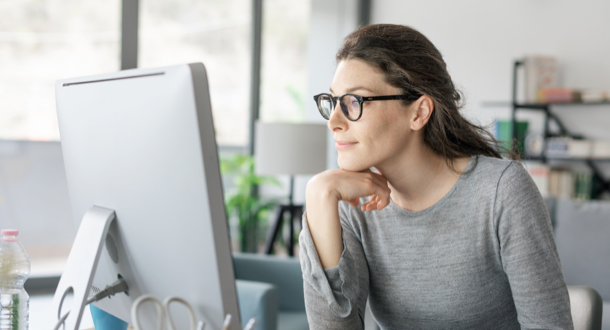 Professional woman sitting at desk and connecting with her computer