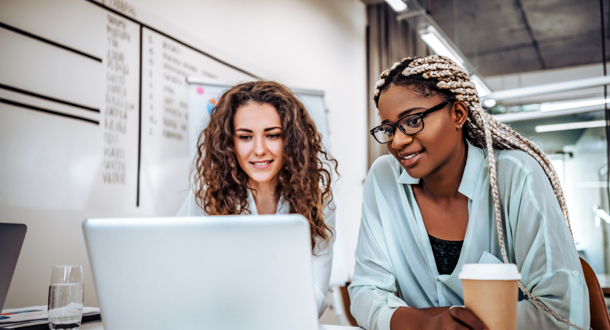 Two female colleagues working on a laptop together