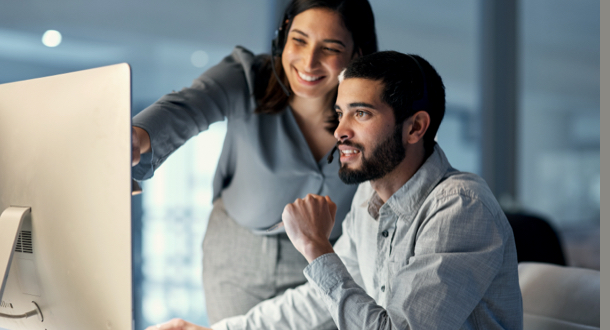 young woman helping her colleague in a call centre late at night