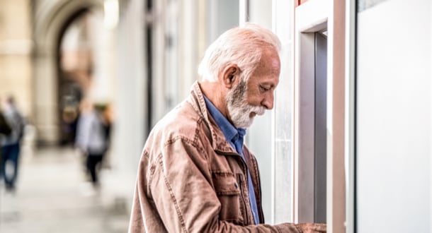 Senior man withdrawing money on ATM machine