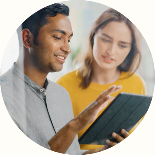 Indian man showing tablet to his female team member 