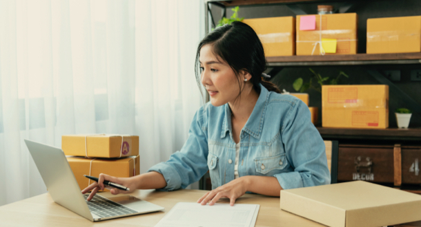 Young woman working on laptop while checking online order