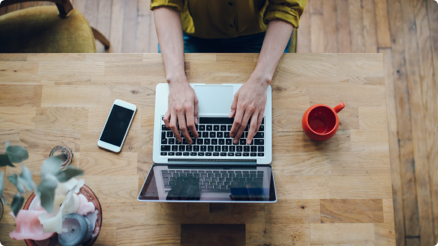 overhead of a female working on laptop at desk