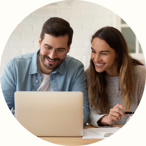 happy young couple looking using loan management tools on laptop