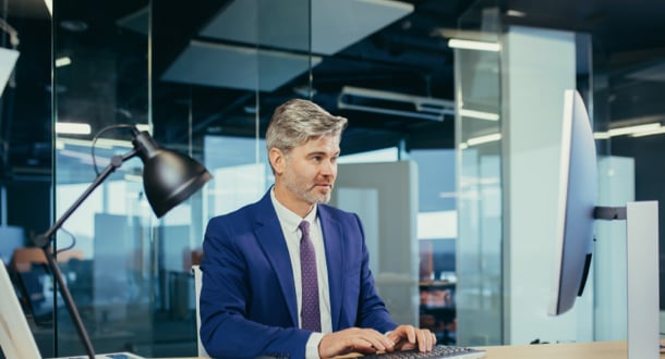 pensive businessman working at computer in modern office