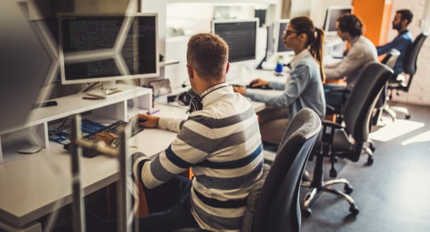 Group of programmers developing new software on computers in the office