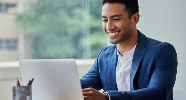 Smiling businessman working on his laptop