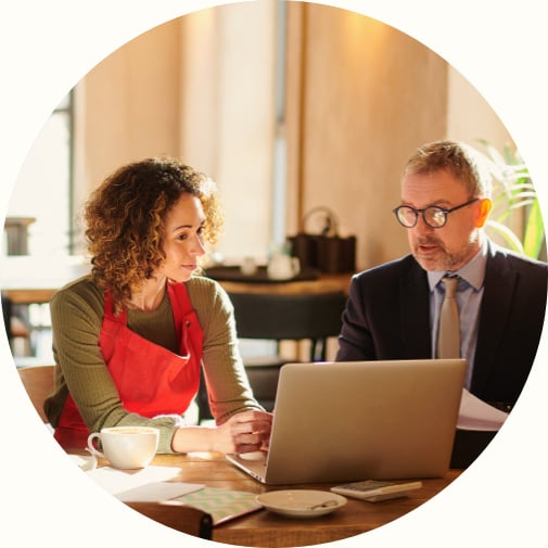 female cafe owner reviewing small business lending options with male advisor in cafe