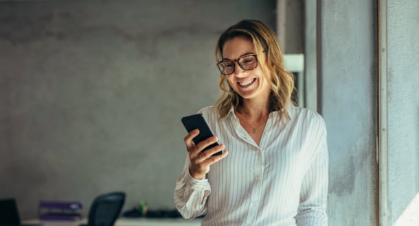 Smiling businesswoman using phone in office