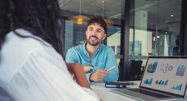 male and female coworker discussing data over desk