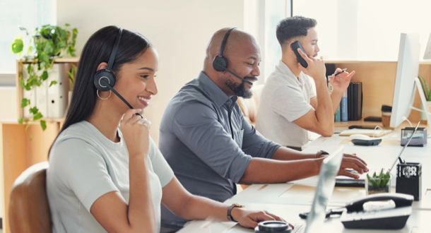 three employees working at call center addressing incoming calls