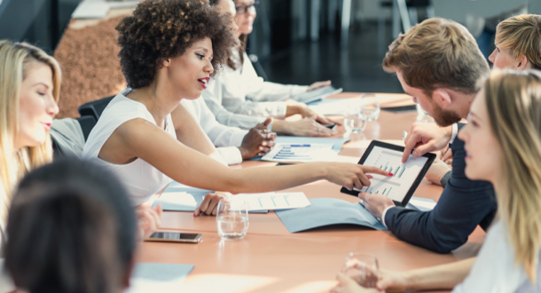 coworkers collaborating over table with ipad