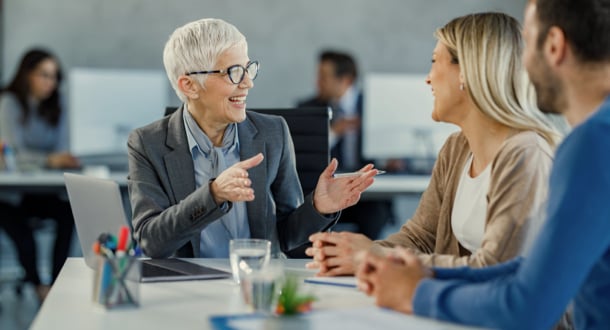 happy senior agent talking to a couple during a meeting in the office.