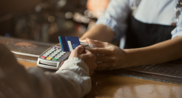 Contactless payment concept, female customer holding credit card near nfc technology on counter