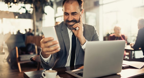  business man enjoying coffee in a cafe and using his phone