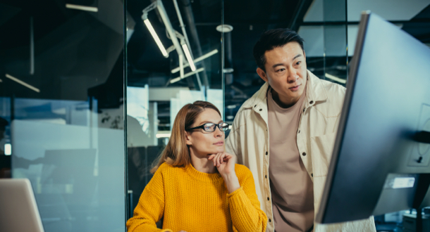 woman and male coworkers managing fraud risk on computer in offce