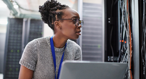 young woman using a laptop in a server room