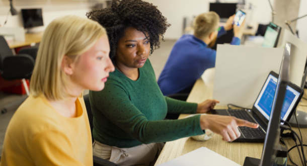 two female coworkers reviewing computer together