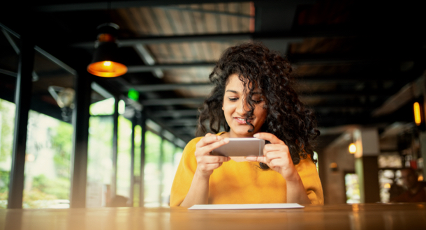 Young Indian woman making a photo of a check at the bar