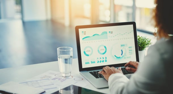 woman working on laptop with graphs displayed