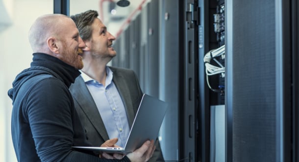 Male Adult Technicians and Manager working together in Server Room