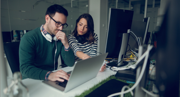 Two web designers working in office on a project together.