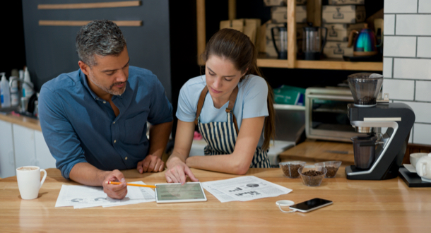 Coffee shop owners reviewing information on a tablet device