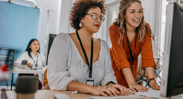 Two businesswomen working together on computer at office